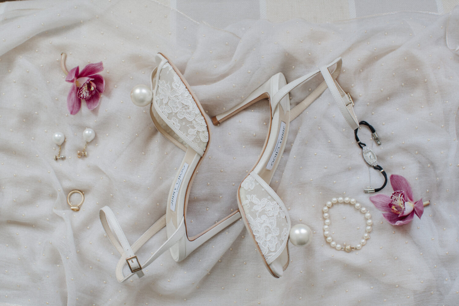 up close shot of jimmy choo lace and pearl wedding pumps