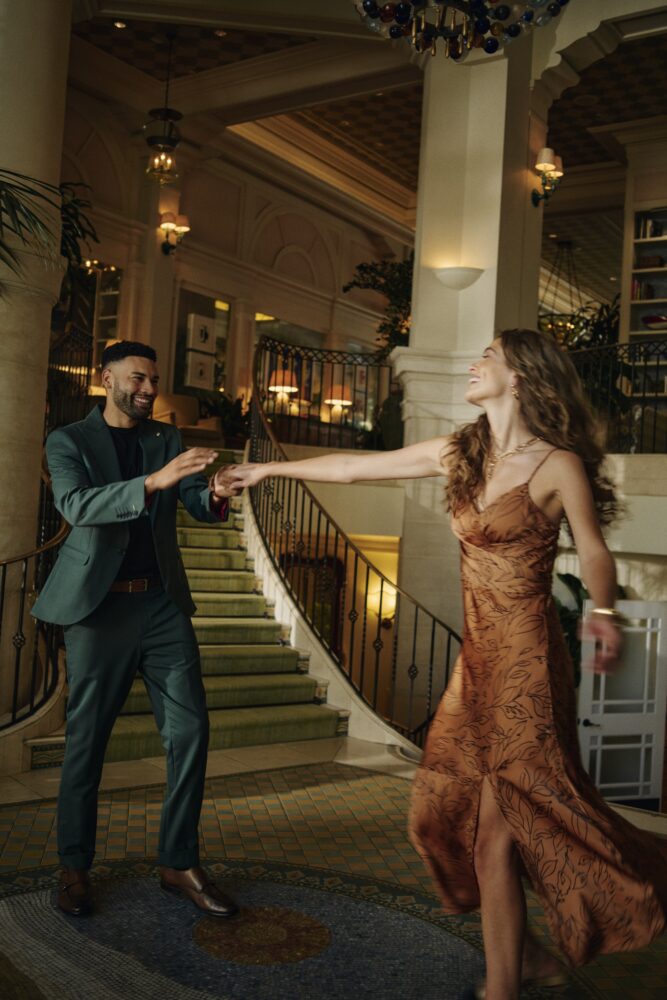 A couple dancing on a mosaic-tiled floor by the staircase.