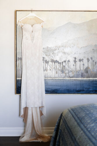 beautiful wedding dress hanging on a painting in hotel room
